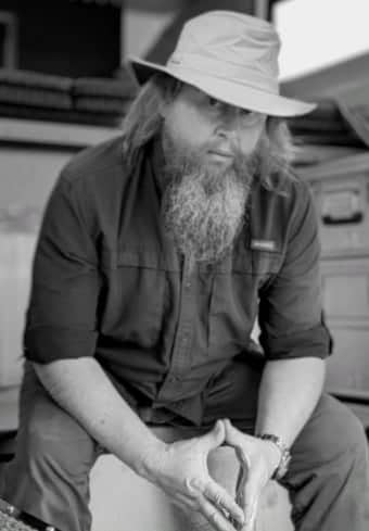 Bearded overlander resting beside his four-season solar RV